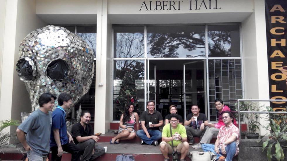 faculty, graduate students, and fellows gathered in front of Albert Hall, with skull lantern made of old cds